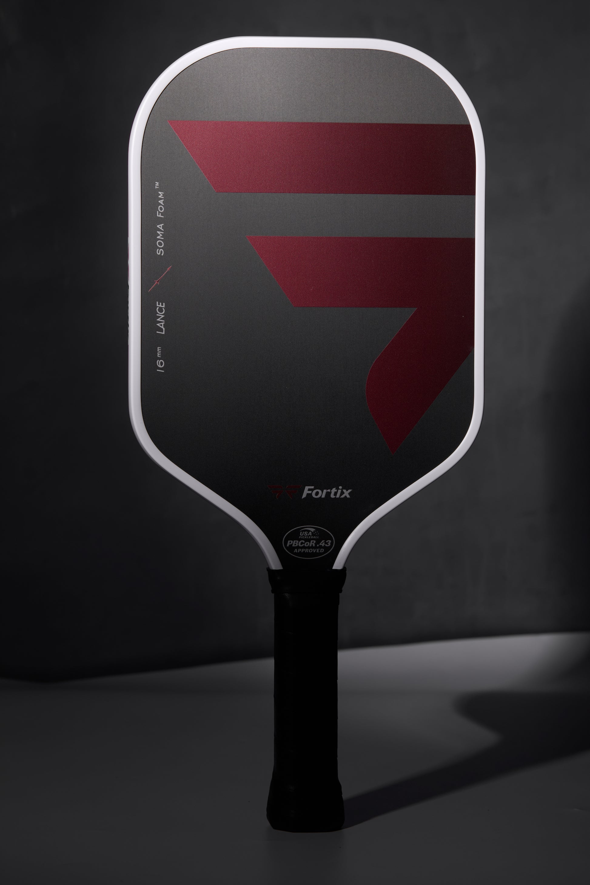 Fortix elongated pickleball paddle with black face and red geometric graphics, black grip